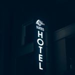 a hotel sign lit up in the dark