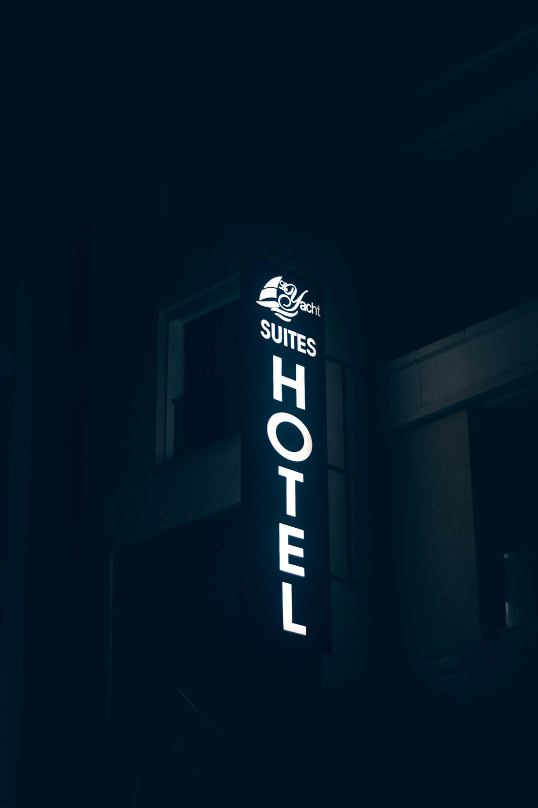 a hotel sign lit up in the dark
