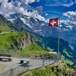 a flag on a pole in front of a mountain range