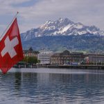 a swiss flag on a boat in the water