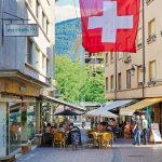 A red and white flag flying over a city street