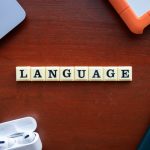 the word language spelled with scrabble tiles on a table
