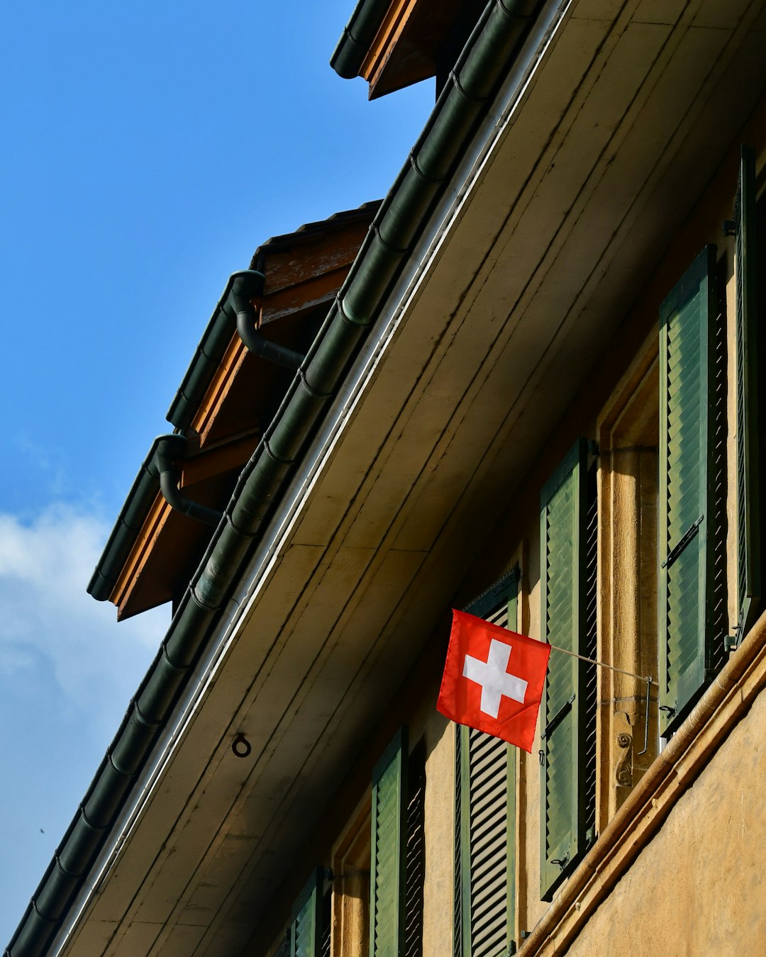 A red and white flag is hanging from the side of a building