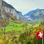 A swiss flag flying high in the mountains