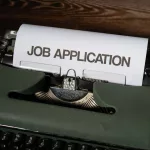 a typewriter with a job application printed on it