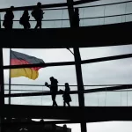 a group of people standing on a bridge holding a flag