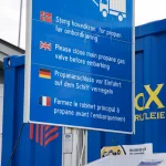 a blue sign with a white truck in the background